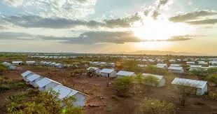 Aid convoy and shelter tents in an arid displacement site in Sudan